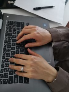 Hands typing on laptop keyboard